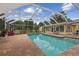 A sparkling screened pool is set in a brick patio with views of the home at 1703 Ryan Dr, Lutz, FL 33549