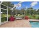 Screened patio with porch swing and manicured landscaping offers serene views at 1703 Ryan Dr, Lutz, FL 33549