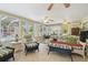 Bright sunroom featuring ceiling fans, tile flooring, and comfortable wicker furniture at 1703 Ryan Dr, Lutz, FL 33549
