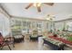 Relaxing sunroom with tile flooring, fan, and wicker furniture for enjoying the outdoor view at 1703 Ryan Dr, Lutz, FL 33549
