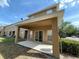A covered back patio with sliding glass doors and neutral colored concrete flooring at 10402 Tulip Field Way, Riverview, FL 33578