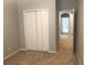 Neutral bedroom featuring a closet, tan carpet, and an open doorway at 10402 Tulip Field Way, Riverview, FL 33578