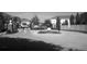Entrance to the community with mature trees and maintained landscaping in greyscale at 10402 Tulip Field Way, Riverview, FL 33578