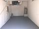 An attached garage with an epoxy floor, new water heater and an HVAC unit at 10402 Tulip Field Way, Riverview, FL 33578