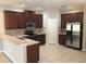 Well-lit kitchen featuring stainless steel appliances, wood cabinets, and tile flooring at 10402 Tulip Field Way, Riverview, FL 33578