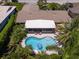 Aerial shot of a single-Gathering home with a screened-in patio, kidney-shaped pool, and lush, mature landscaping at 10515 Hetrick W Cir, Largo, FL 33774