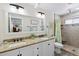 Bathroom with a double vanity and granite countertops offers plenty of counter space and a walk-in shower at 10515 Hetrick W Cir, Largo, FL 33774