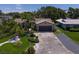 Well-manicured lawn and landscaping showing tropical foliage and a two-car garage and additional parking at 10515 Hetrick W Cir, Largo, FL 33774