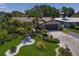 Landscaped front yard with lush green grass, palm trees, and decorative white rock accents leading to a charming home at 10515 Hetrick W Cir, Largo, FL 33774