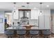 Bright kitchen with stainless steel appliances, light wood floors, stone counters and a large island with seating at 10515 Hetrick W Cir, Largo, FL 33774