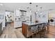 Bright kitchen with stainless steel appliances, light wood floors, stone counters and a large island with seating at 10515 Hetrick W Cir, Largo, FL 33774