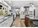 Bright kitchen with stainless steel appliances, light wood floors, stone counters and a large island with seating at 10515 Hetrick W Cir, Largo, FL 33774