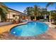 Beautiful backyard pool with a spacious patio, palm trees, and an outdoor bar area at 10515 Hetrick W Cir, Largo, FL 33774