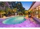 Night view of the pool and patio area with lush landscaping and outdoor seating at 10515 Hetrick W Cir, Largo, FL 33774