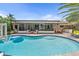 Heated swimming pool and spa with seating area and views of the backyard at 10515 Hetrick W Cir, Largo, FL 33774