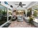 Relax in the screened-in sunroom, featuring tile floors, a ceiling fan, and backyard views at 10515 Hetrick W Cir, Largo, FL 33774