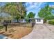 Single-story home with mature trees, a black fence, a concrete driveway, and well-maintained landscaping at 11308 N Hamner Ave, Tampa, FL 33612