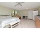 Open living space with a seating area, a bed and an efficiency kitchen with stainless steel refrigerator at 11308 N Hamner Ave, Tampa, FL 33612