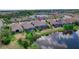 An aerial view displays the home next to a serene pond, highlighting its screened-in patio at 11411 Juglans Dr, Odessa, FL 33556
