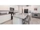Modern kitchen with a gray island, black appliances, and white cabinets at 11830 Brighton Knoll Loop, Riverview, FL 33579