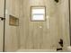 Bathroom featuring a shower with a tile surround, a window, and a built-in niche at 12484 Cross St, Largo, FL 33773