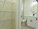 Bathroom with a storage closet, tile tub surround, modern vanity, and a round mirror at 12484 Cross St, Largo, FL 33773