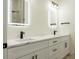 Modern bathroom featuring double sinks, lighted mirrors, and stylish black and gold fixtures at 12484 Cross St, Largo, FL 33773
