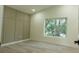 Bright bedroom with board and batten wall accent, neutral walls, and large window providing ample light at 12484 Cross St, Largo, FL 33773