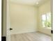 Simple bedroom featuring wood-look flooring, a bright window, and neutral walls at 12484 Cross St, Largo, FL 33773