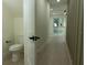 Hallway with a peek into the half bathroom including a toilet at 12484 Cross St, Largo, FL 33773