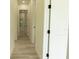 Bright hallway with wood-look flooring and white doors offering a modern and clean aesthetic at 12484 Cross St, Largo, FL 33773