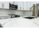 Well-equipped kitchen with white cabinetry, stainless steel appliances, gold hardware, and marble countertops at 12484 Cross St, Largo, FL 33773