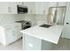 Modern kitchen featuring white cabinets, quartz countertops, stainless steel appliances, and a stylish kitchen island at 12484 Cross St, Largo, FL 33773
