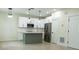 Modern kitchen with white cabinets, stainless steel appliances, and a gray-green island at 12484 Cross St, Largo, FL 33773