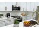 Stylish kitchen with white cabinets, stainless steel appliances, and marble countertops at 12484 Cross St, Largo, FL 33773