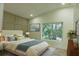 Comfortable main bedroom features a plush bed, wainscoting wall, and a window overlooking trees at 12484 Cross St, Largo, FL 33773