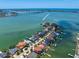 Stunning aerial view of waterfront homes, featuring boat docks and clear blue water in the distance at 14 Sunset Bay Dr, Belleair, FL 33756