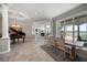 Elegant dining area with tiled floors, a grand piano, and serene water views at 14 Sunset Bay Dr, Belleair, FL 33756