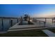 Well-lit boat dock and lift at twilight, offering stunning views of the water at 14 Sunset Bay Dr, Belleair, FL 33756