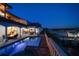 An exterior photo of the back of the home showing the pool, outdoor patio, and access to the private dock and boat lift at 14 Sunset Bay Dr, Belleair, FL 33756
