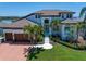 Beautiful home with a well-manicured lawn, elegant landscaping, and a grand entrance with an arched doorway at 14 Sunset Bay Dr, Belleair, FL 33756