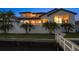 Back of house featuring a white stucco exterior, a 2nd story balcony, pool, and private dock at 14 Sunset Bay Dr, Belleair, FL 33756