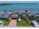 Beautiful waterfront home with lush landscaping, a brick driveway, and stunning water views at 14 Sunset Bay Dr, Belleair, FL 33756