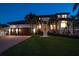 Beautiful home with a well-manicured lawn, elegant landscaping, and a grand entrance at night at 14 Sunset Bay Dr, Belleair, FL 33756