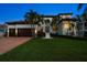 Beautifully landscaped front yard and a two-car garage compliment this Mediterranean-style home at 14 Sunset Bay Dr, Belleair, FL 33756