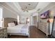 Comfortable bedroom with a neutral color palette, tray ceiling, and wood floors at 14 Sunset Bay Dr, Belleair, FL 33756