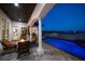 A covered patio with a firepit overlooks a private pool, with views of the channel at 14 Sunset Bay Dr, Belleair, FL 33756