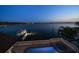 Twilight view of waterfront pool, dock, and city lights beyond at 14 Sunset Bay Dr, Belleair, FL 33756