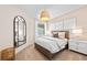 Bedroom featuring white walls, a bed with decorative pillows, bedside tables, and a modern light fixture at 14313 Eagle Branch Dr, Nokomis, FL 34275