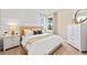 Cozy bedroom with a plush bed, shiplap wall, bedside tables, and a bright window with natural light at 14313 Eagle Branch Dr, Nokomis, FL 34275